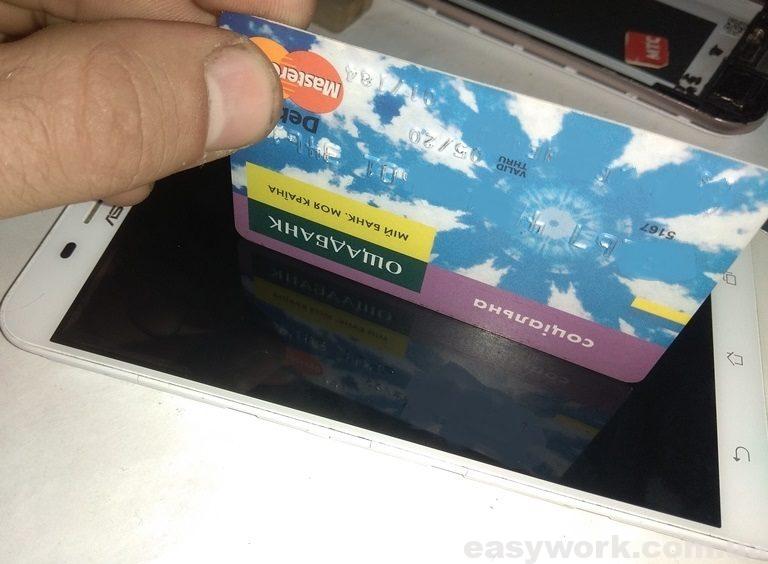 Отражение банковской карточки на экране телефона